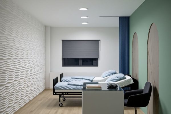 Modern hospital patient room with bed, desk, and minimalist interior design